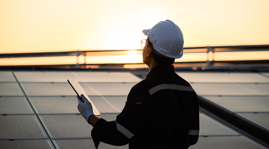 Sustainability engineer in front of wind tower
